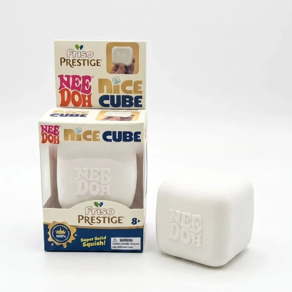 NeeDoh Luminous Milk Cube Squishy on a desk, softly glowing and showing its milky coffee cube shape — Image 1 of 5