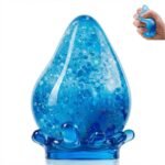 Blue giant NeeDoh Dream Drop raindrop squishy sitting on its clear splash-shaped display stand — Image 1 of 7