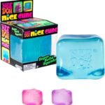Frosted translucent NeeDoh Nice Cube ice-cube-shaped squishy in blue resting on a table, with soft light showing its see-through texture. — Image 1 of 6